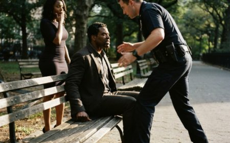"Just eating breakfast, officer," the Black man said calmly, hot dog in one hand, coffee in the other. That's when the cop stepped closer, crushed the hot dog under his boot, and poured cold coffee over the man's head in front of eight witnesses. The man wiped his face, reached into his jacket, and said five words that made the officer freeze completely — because that "filthy" stranger was actually a decorated detective who'd just spent eight months working deep undercover. And those five words destroyed everything.