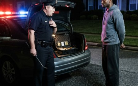 "Turn around, face the car. Put your hands on the roof," the officer barked, his flashlight blinding the Black couple he'd just pulled over in an affluent suburb. Elijah complied without a word, his hands flat on the cold metal of his Mercedes. The cop thought he was just another easy target in the wrong neighborhood — until he pried open a locked case in the trunk, and the gold badges staring back at him belonged to the FBI and the Department of Justice. Then the terrified officer realized he hadn't made a traffic stop at all. He'd just committed a federal crime.