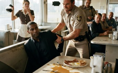 "Take him outside," Sheriff Wade Mercer ordered, dragging Calvin Brooks from his breakfast booth in full view of the diner. The handcuffs clicked shut while his eggs went cold. Then Calvin calmly told the waitress to call the number in his jacket lining—and when Wade Mercer opened that leather wallet, his face drained in patches, because the man he'd just humiliated was looking back at him from a gold federal seal as the Director of the FBI.